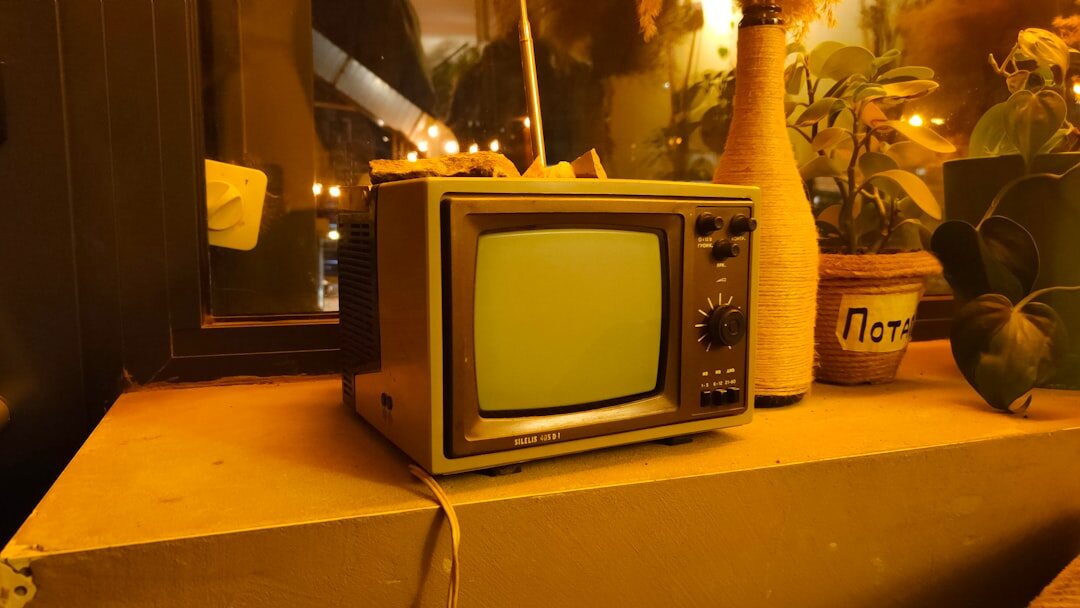 Old cathode ray tube television set glowing on a wooden shelf
